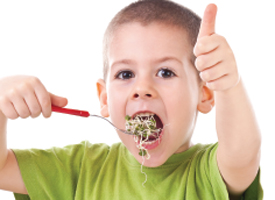 Child giving thumbs up to vegetables
