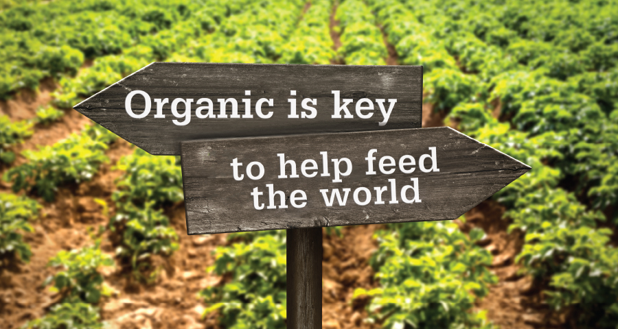 Sign in field of crops with message: Organic is key to help feed the world