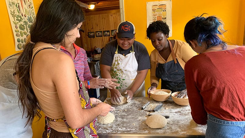 Arvin Batingan, Daela Muñoz and Chef Natalie Evans baking at an event at Quillisicut Farm. 