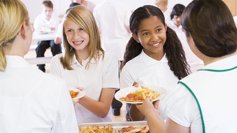 Kids in cafeteria receiving unhealthy lunch