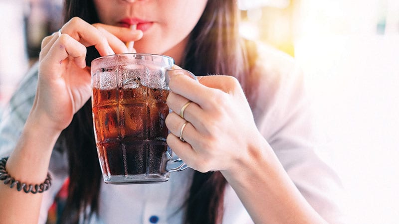 Woman drinking a glass of soda